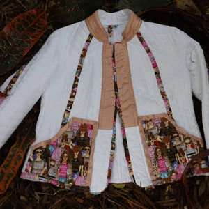 May include: White quilted jacket with a mandarin collar and a zipper closure. The jacket has a brown trim and a patterned fabric lining with a design of women in various poses.