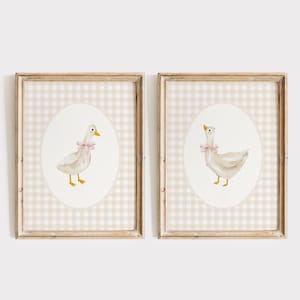 May include: Two framed prints with a beige and white gingham background. Each print features a white duck with a pink bow on a white oval.