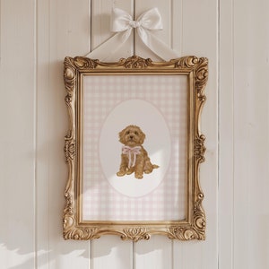 May include: A framed print of a brown and white dog wearing a pink bow, sitting on a pink and white gingham background.