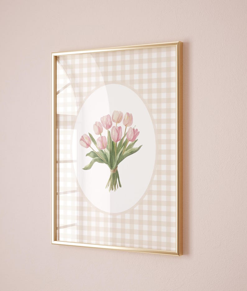 Pu&ograve; includere: Una stampa incorniciata con un'illustrazione ad acquerello di un mazzo di tulipani rosa su sfondo bianco con un bordo a quadri marroni e bianchi.