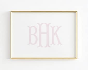 May include: A gold framed picture with a pale pink monogram of the letters "BHK" in a traditional script font.