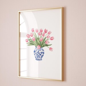 May include: A framed watercolor painting of a bouquet of pink tulips in a blue and white porcelain vase.