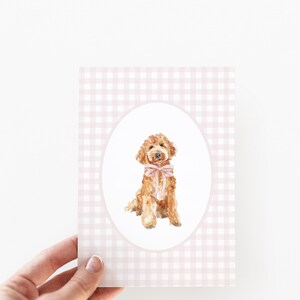 May include: A watercolor illustration of a brown dog wearing a pink bow, set against a pink and white gingham background.