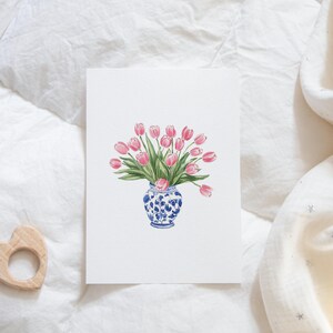 May include: A watercolor painting of a bouquet of pink tulips in a blue and white porcelain vase. The vase has a floral pattern.