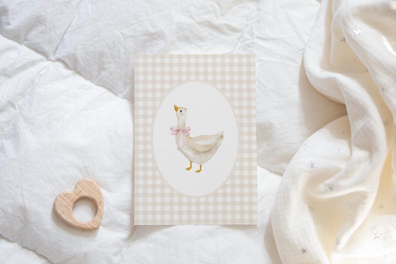 May include: A white goose with a pink bow on a beige and white gingham background.