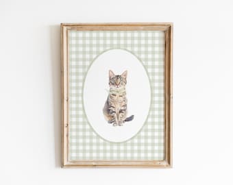 May include: A framed print of a watercolor painting of a tabby cat sitting on a green and white gingham background.