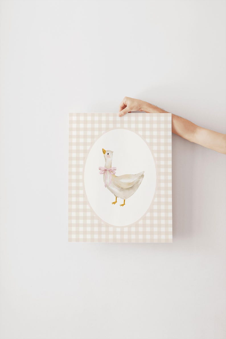May include: A white goose with a pink bow is illustrated on a light pink and white gingham background. The goose is in an oval frame.
