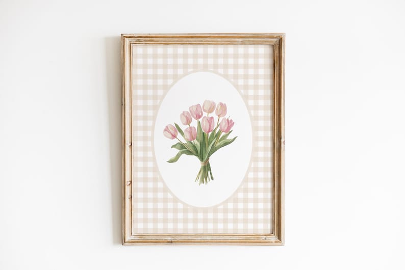 Pu&ograve; includere: Una stampa incorniciata di un dipinto ad acquerello di un mazzo di tulipani rosa su uno sfondo a quadri beige e bianco.