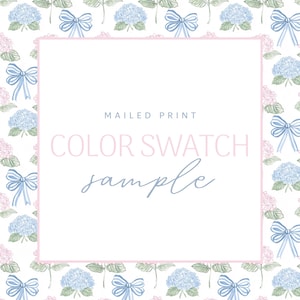 May include: A white background with a repeating pattern of blue bows and hydrangea flowers in pink and blue. The center features a pink-bordered square with the text "MAILED PRINT COLOR SWATCH sample" in pink and blue.