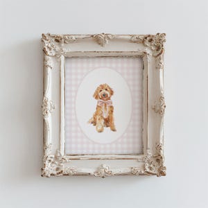 May include: A watercolor painting of a brown dog wearing a pink bow, framed in a white ornate frame with a pink and white gingham background.