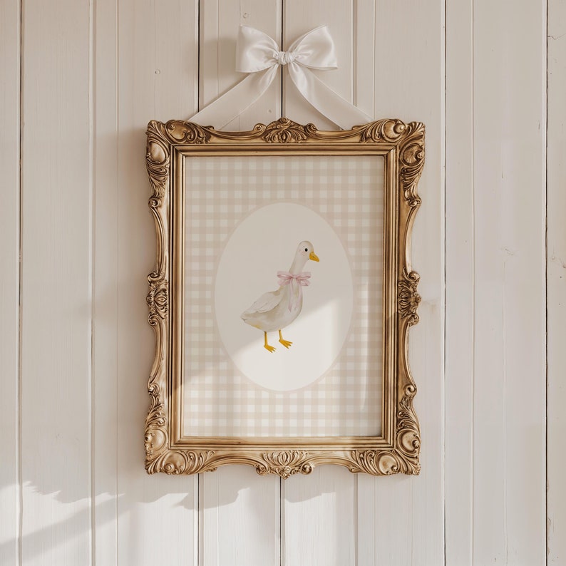 May include: A framed print of a watercolor illustration of a white duck with a pink bow on a gingham background.