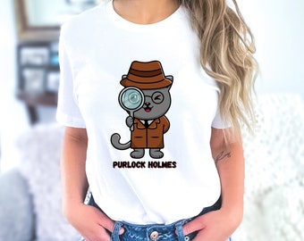 May include: White t-shirt featuring a cartoon illustration of a cat wearing a detective hat and holding a magnifying glass. The text "Purlock Holmes" is printed below the image.
