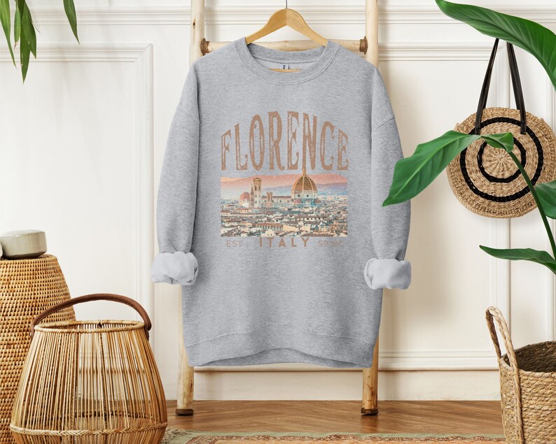May include: A gray sweatshirt with a graphic print of the Florence skyline and the text "Florence Est. Italy Sp. 1970".