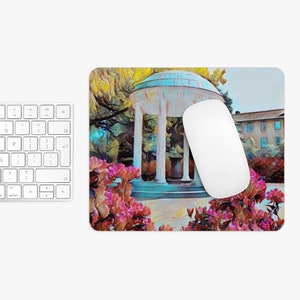 May include: A white, columned gazebo with a blue roof surrounded by pink flowers. The gazebo is set against a backdrop of green trees and a blue sky.