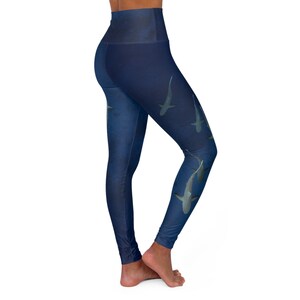 May include: Blue yoga leggings with a high waist and a shark print. The leggings are made of a stretchy, comfortable fabric and are perfect for yoga, running, or any other workout.