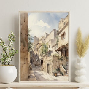 May include: Watercolor painting of a narrow street in a European city. The street is lined with stone buildings, and there are trees and plants growing along the sides. The buildings are painted in shades of beige and brown, and the street is paved with cobblestones.