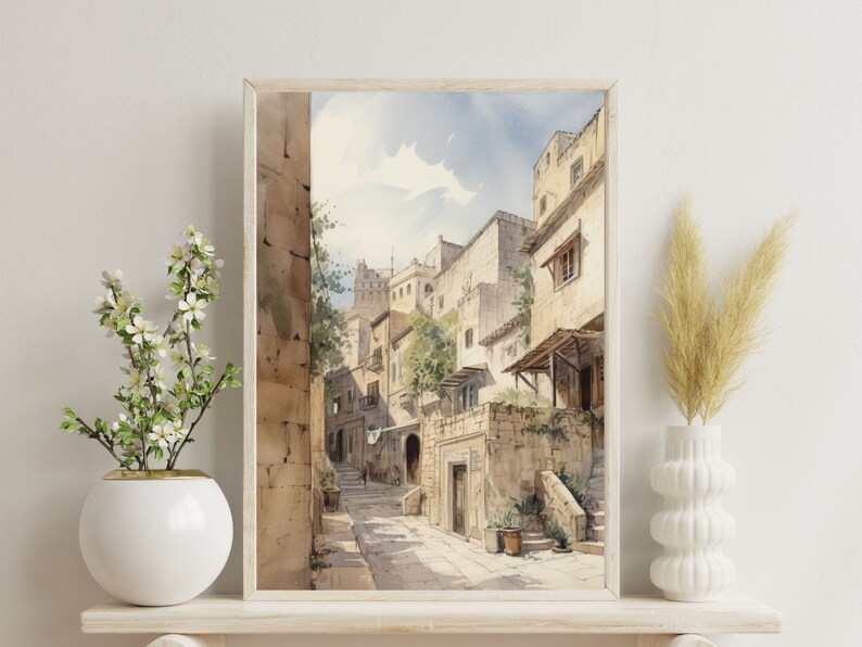 May include: Watercolor painting of a narrow street in a European city. The street is lined with stone buildings, and there are trees and plants growing along the sides. The buildings are painted in shades of beige and brown, and the street is paved with cobblestones.