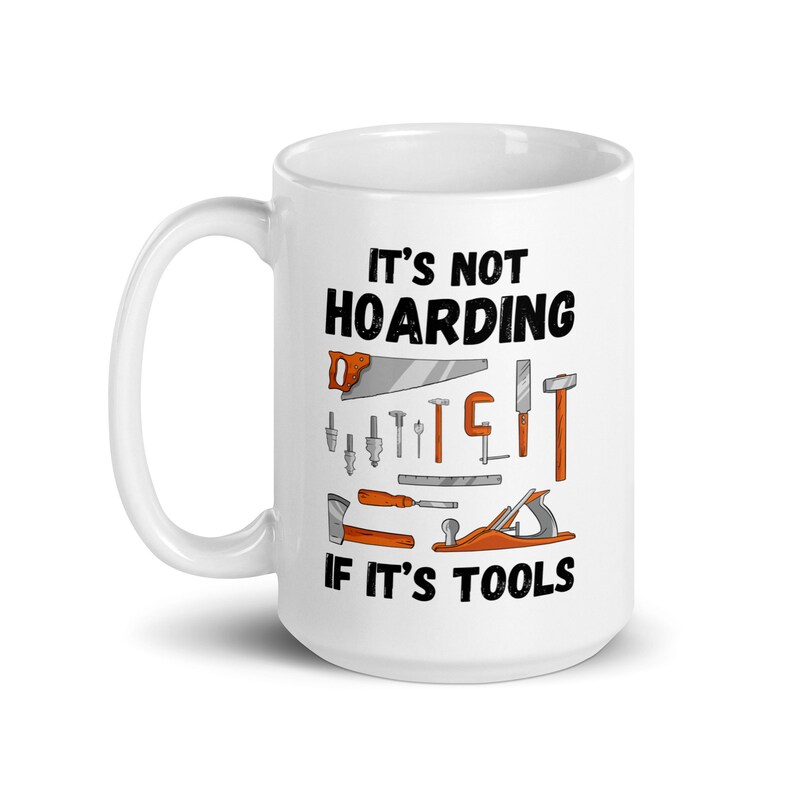 May include: White ceramic mug with a black and orange design. The mug features the text "It's not hoarding if it's tools" and an illustration of various tools, including a saw, hammer, screwdriver, and wrench.