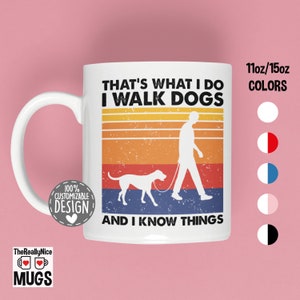 May include: White ceramic mug with a retro design featuring a person walking a dog. The text on the mug reads "That's what I do I walk dogs and I know things".