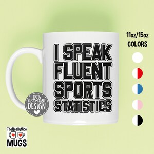 May include: White ceramic mug with black text that reads "I Speak Fluent Sports Statistics". The mug is 11oz or 15oz and is available in white, red and white, blue and white, pink and white, and black and white.