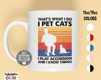 Könnte beinhalten: Weiße Keramiktasse mit einem Retro-Design, das eine Silhouette einer Person zeigt, die Akkordeon spielt, und eine Katze. Der Text lautet "That's what I do I pet cats I play accordion and I know things".