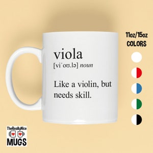 May include: White ceramic coffee mug with a black design that says "viola [vi'ov.lǝ] noun Like a violin, but needs skill." The mug is 11oz/15oz and is available in white, red, blue, green, and black.