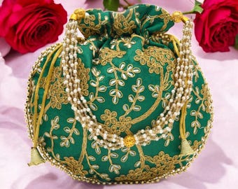 以下が含まれることがあります： 金色の花柄とビーズストラップが付いた、緑色の刺繍ポーチ。巾着袋は丸い形で、金色のアクセントが付いています。バッグは白いビーズと金色のタッセルで飾られています。