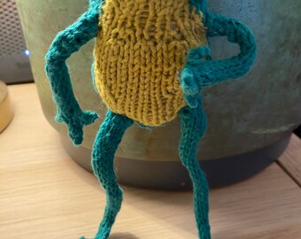 Bright bold green hand knitted pocket frog with mustard gold tummy