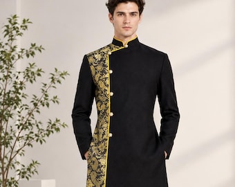 Op de afbeelding: Een zwarte knielange tuniek met een mandarijnkraag en lange mouwen. Het kledingstuk heeft een verticaal paneel aan de rechterkant versierd met een goudkleurig bloemmotief, geaccentueerd door een felgele bies en vier ronde goudkleurige knopen.
