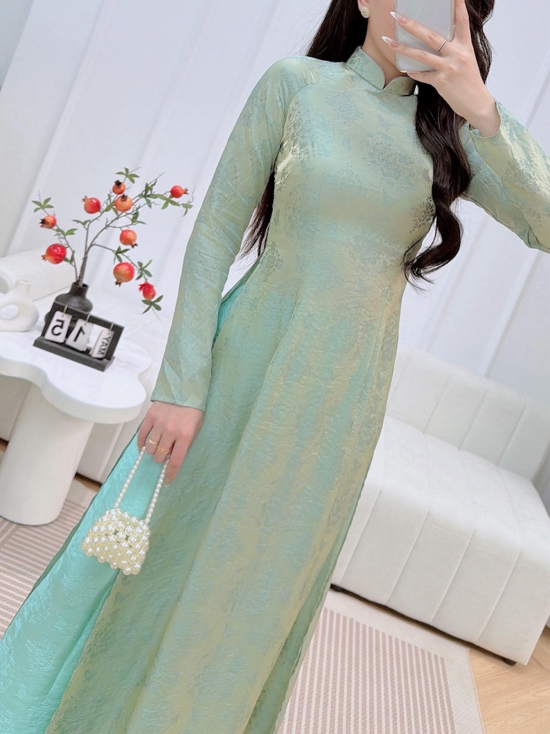 May include: A white ceramic mug with a black handle and the text "But First, Coffee" in a black, bold font. The mug is on a white surface.