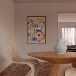 May include: A wooden dining table with a round top and a white ceramic vase with a white pitcher on top. Two white chairs are on either side of the table. A framed print with a red and blue illustration of food and drink is on the wall behind the table.