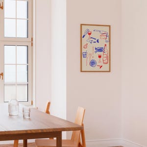 May include: A framed illustration of a variety of food and drink items, including a fish, a crab, a bottle of wine, a glass of wine, a lemon, a knife, a fork, a whisk, a cheese wedge, and a corkscrew. The illustration is in blue and red on a cream background.