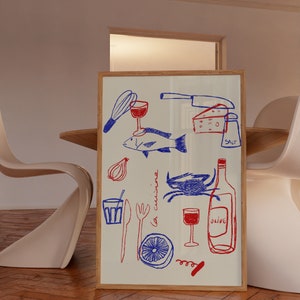 May include: A framed illustration of a kitchen scene with red and blue drawings of food, wine, and kitchen utensils. The text "la cucina" is written in blue on the white background.