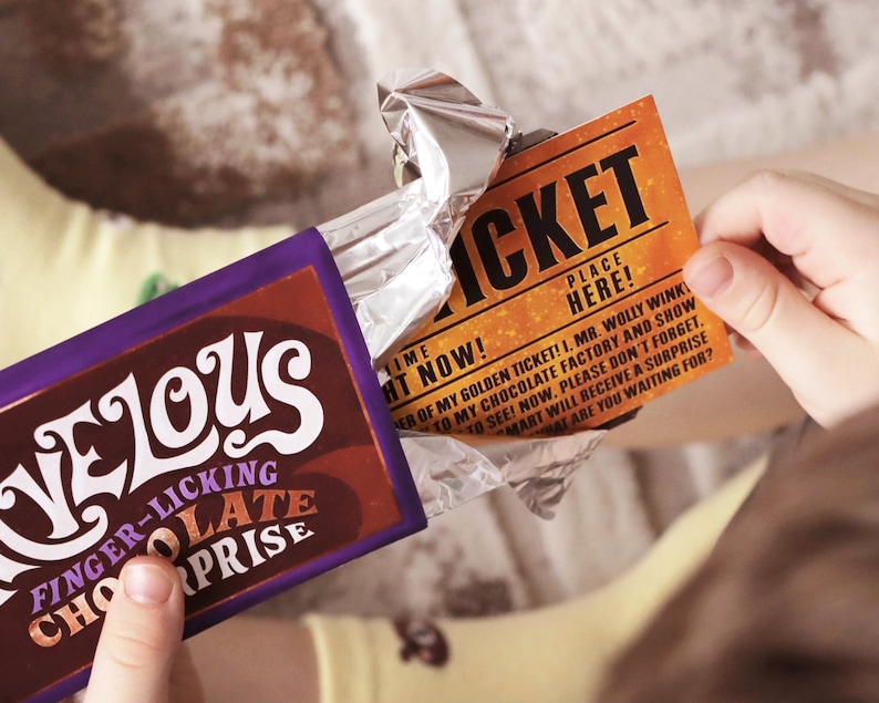 May include: A purple and brown chocolate bar with the text "Velous Finger-licking Chocolate Surprise" on the front. The bar is partially unwrapped, revealing a golden ticket with the text "Ticket Place Here!" and a message about a chocolate factory.