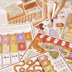 May include: A collection of colorful ice cream-themed activity sheets with various puzzles and games. The sheets feature illustrations of ice cream cones, characters, and the text "Welcome to TaSTAtous". A white marker is held above the sheets.
