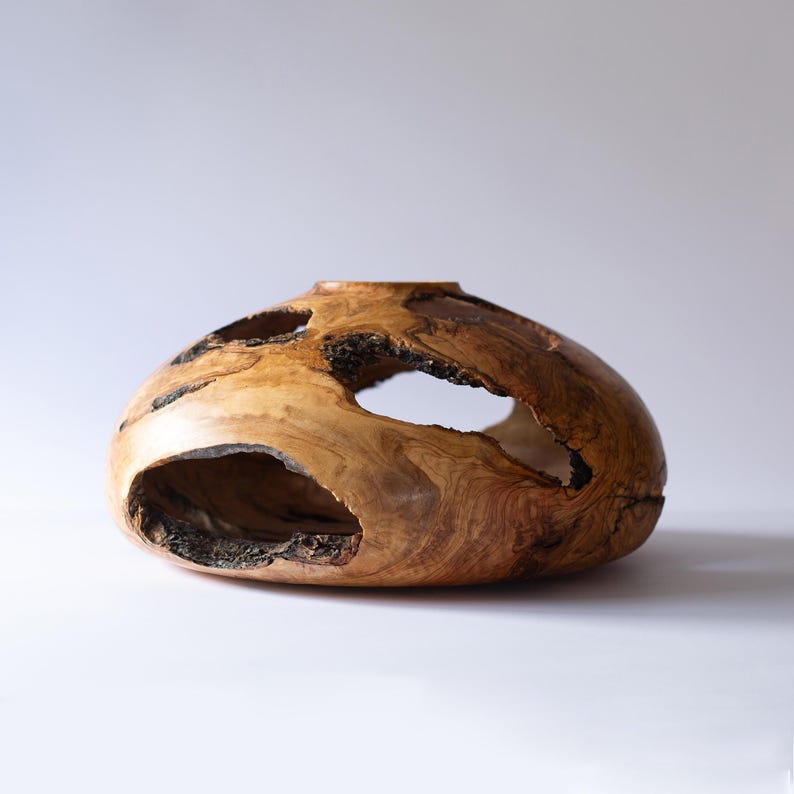 Natural olive wood vase for dining table, hand-turned with open cavities.