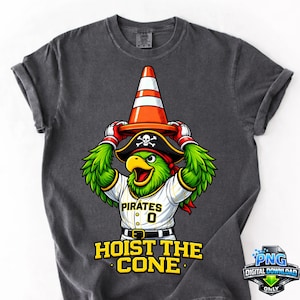 May include: Dark gray t-shirt featuring a cartoon parrot wearing a pirate hat and a traffic cone. The parrot is wearing a baseball jersey with the word "Pirates" and the number "0". The text "HOIST THE CONE" is printed below the parrot.