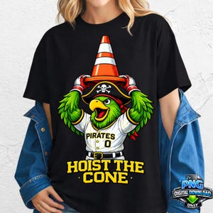 May include: Black t-shirt featuring a cartoon parrot wearing a pirate hat and holding a traffic cone. The parrot is wearing a baseball jersey with the word "Pirates" and the number "0". The text "HOIST THE CONE" is below the parrot.
