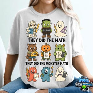 Può includere: Una t-shirt bianca con una stampa grafica di nove mostri dei cartoni animati impegnati in attività di matematica. Il testo recita "THEY DID THE MATH" e "THEY DID THE MONSTER MATH". I personaggi includono una mummia, Frankenstein, fantasmi, un lupo mannaro, una zucca e creature pelose che tengono in mano matite, righelli, calcolatrici e fogli di matematica.