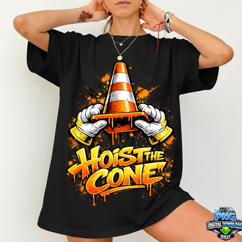 May include: Black t-shirt featuring a cartoon graphic of a traffic cone held by gloved hands, with the text "Hoist the Cone" in orange and yellow. The design includes orange and yellow paint splatters.