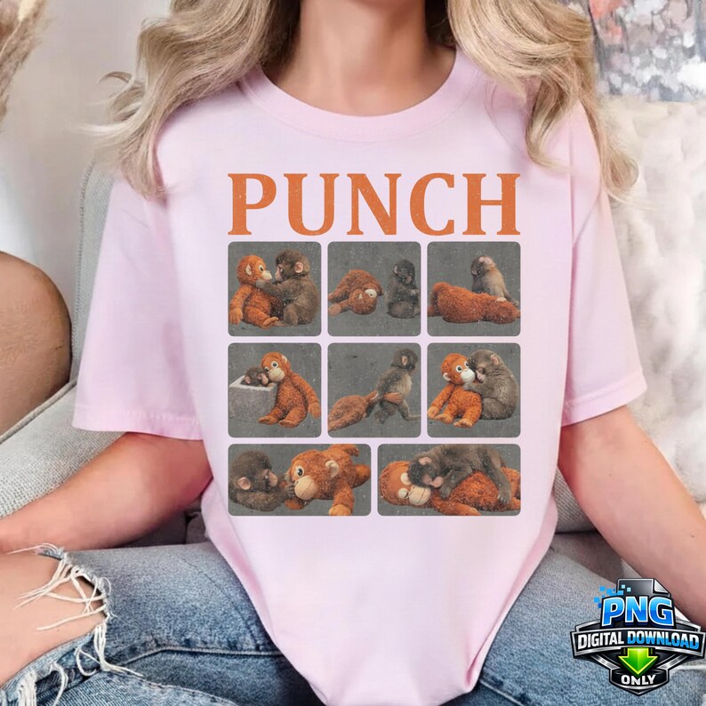 May include: A light pink t-shirt featuring the word "PUNCH" in orange block letters above a grid of nine squares. Each square contains a different illustration of two monkeys in various poses. The shirt has short sleeves.