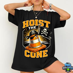 May include: Black t-shirt with a graphic of a pirate traffic cone holding a flag with a skull and crossbones. The text "HOIST THE CONE" is in orange. The cone has a black eye patch and bandana.