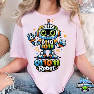 Könnte beinhalten: Hellrosa T-Shirt mit einem bunten Roboter-Design. Der Roboter ist mit Binärcode, orangefarbenen und blauen Details und dem Wort "Robot" darunter verziert. Der Roboter zeigt einen Daumen hoch.