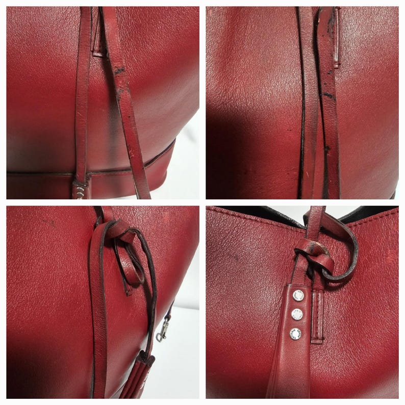 以下が含まれることがあります： 赤い革のトートバッグのクローズアップ。結び目のついたストラップと銀色の金具が付いています。バッグはテクスチャのある革の仕上げで、少し使い込まれたような外観です。