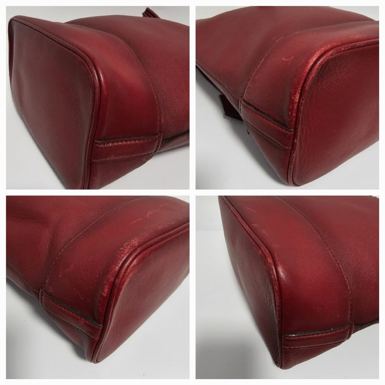 以下が含まれることがあります： 滑らかで質感のある赤い革製のトートバッグのクローズアップ。バッグは構造化された形状で、わずかに丸みを帯びた底をしています。