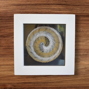 String Art-målning "Spiral Vortex" 18x18 - Guld- och vitvävd i handgjord ram - Modern dekoration med glas för bord eller vägg