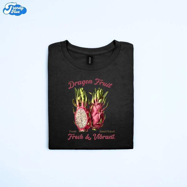 May include: Black t-shirt with a dragon fruit graphic. The design includes two dragon fruits, one cut open to show the interior. Text reads "Dragon Fruit" above and "Fresh & Vibrant" below the image.