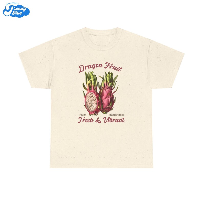 May include: A cream-coloured t-shirt with a vintage illustration of dragon fruit. The design includes the text "Dragon Fruit," "Fresh," "Hand Picked," and "Fresh & Vibrant." The dragon fruit is shown in pink, green, and white.