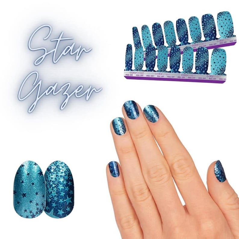 Op de afbeelding: Een set Star Gazer nagellakstrips met een blauwe gradi&euml;ntachtergrond en een donkerblauw sterrenpatroon. De strips worden getoond op twee rechthoekige kaarten en aangebracht op vingernagels, met een glinsterende afwerking en sterrenmotieven.