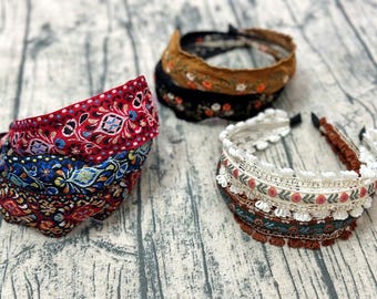 May include: Three different headbands with colorful embroidered patterns. The headbands are made of fabric and have a variety of designs, including floral, geometric, and paisley.
